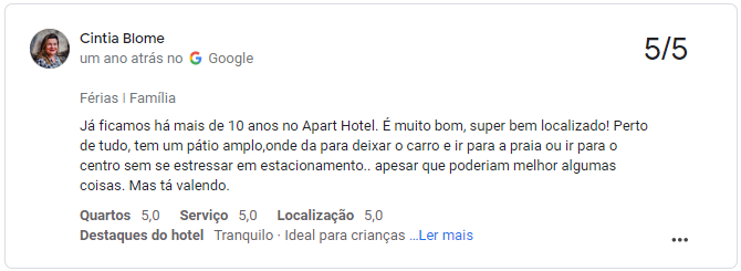 Quarto de casal simples e limpo em pousada barata em Tramandaí com cama arrumada e ventilador.
